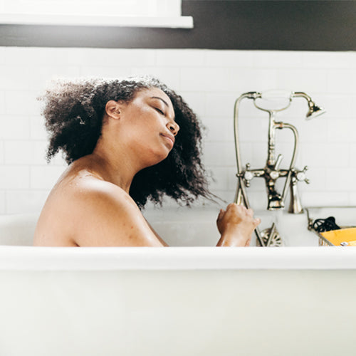Young afro american washing her natural hair