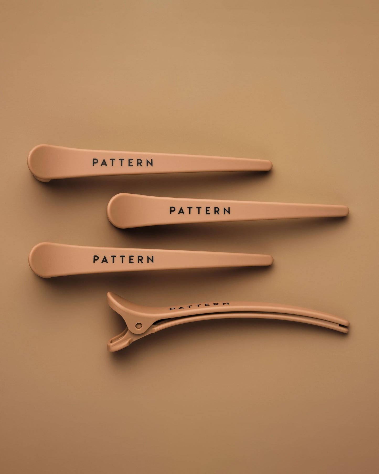 The Curling Iron & More Bundle - Set of four matte tan hair clips with PATTERN Beauty by Tracee Ellis Ross logo on each clip.