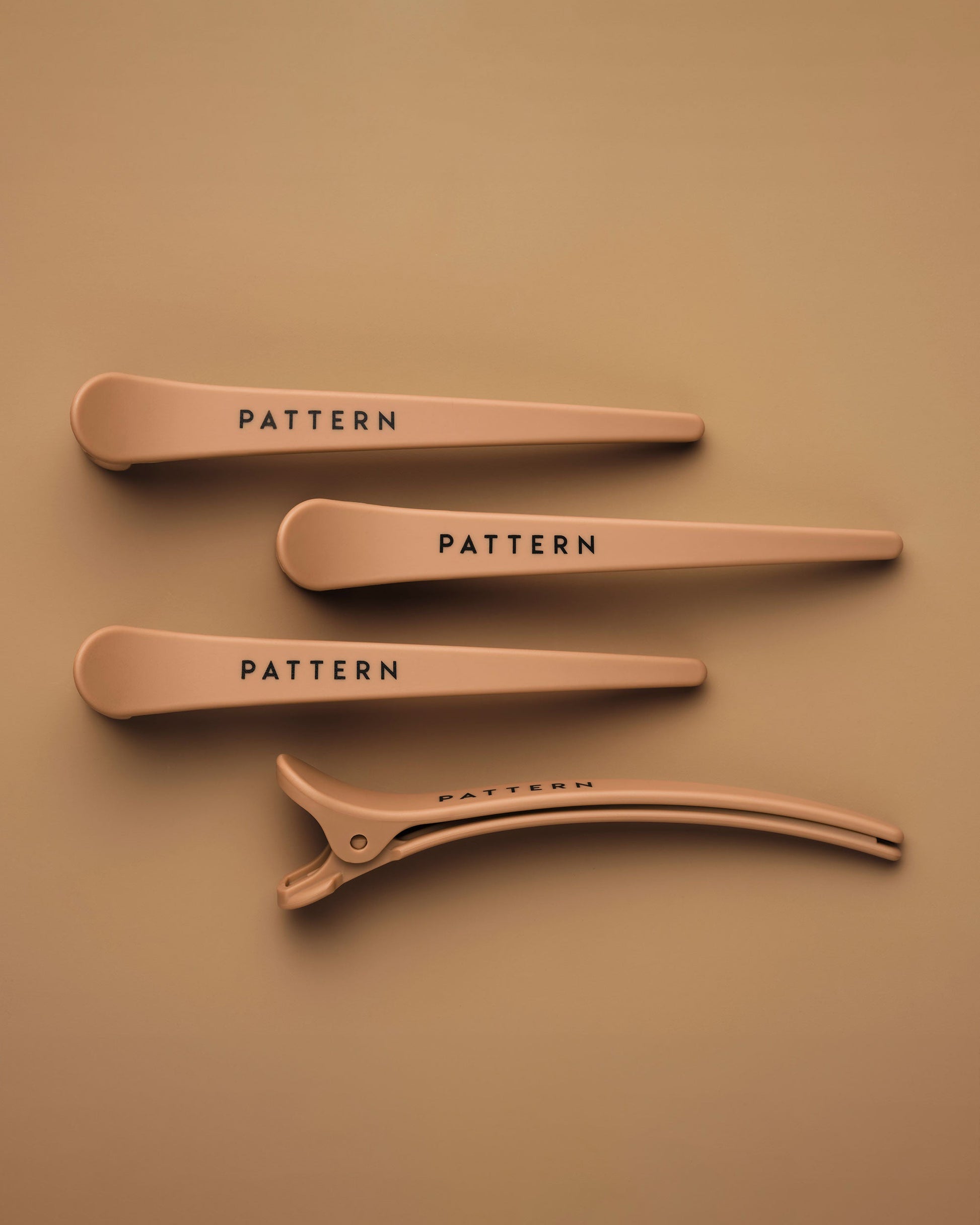 The Curling Iron & More Bundle - Set of four matte tan hair clips with PATTERN Beauty by Tracee Ellis Ross logo on each clip.
