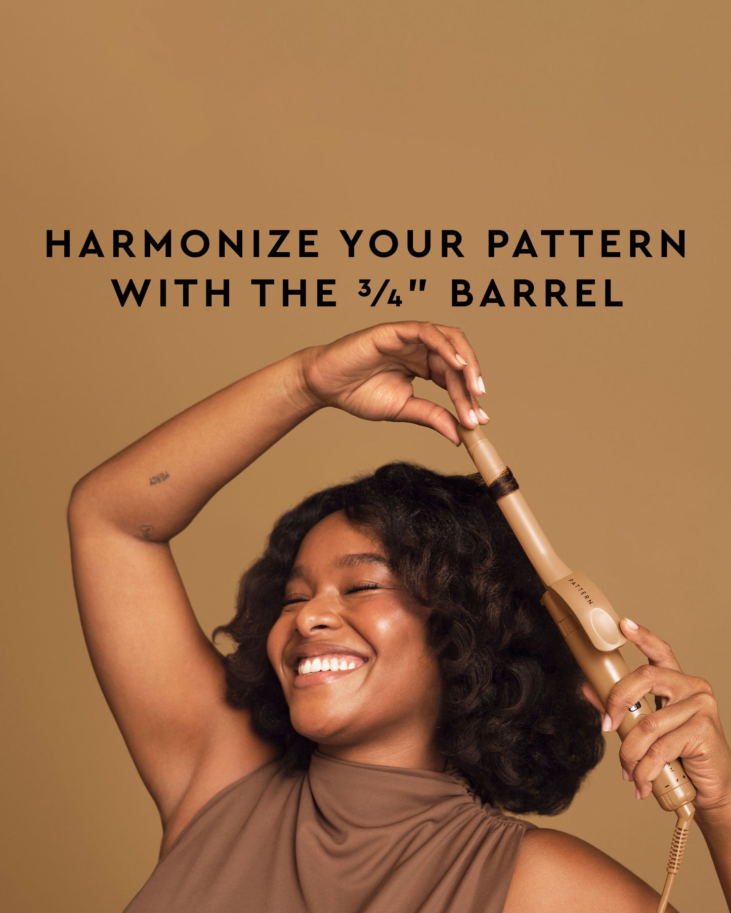The Curling Iron & More Bundle - PATTERN Beauty by Tracee Ellis Ross 3/4-inch curling iron with gold barrel and black handle in hand.