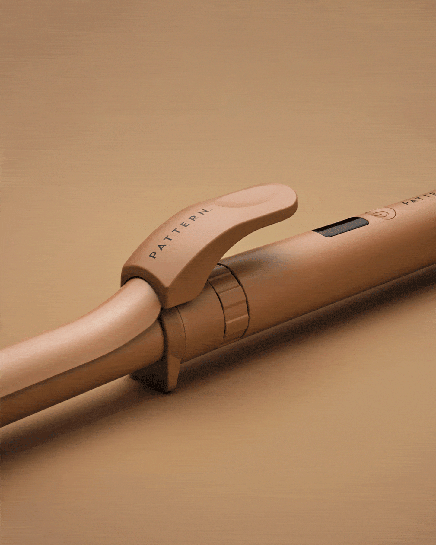 The Curling Iron & More Bundle - Copper-toned curling iron with clamp featuring PATTERN Beauty by Tracee Ellis Ross branding on handle.