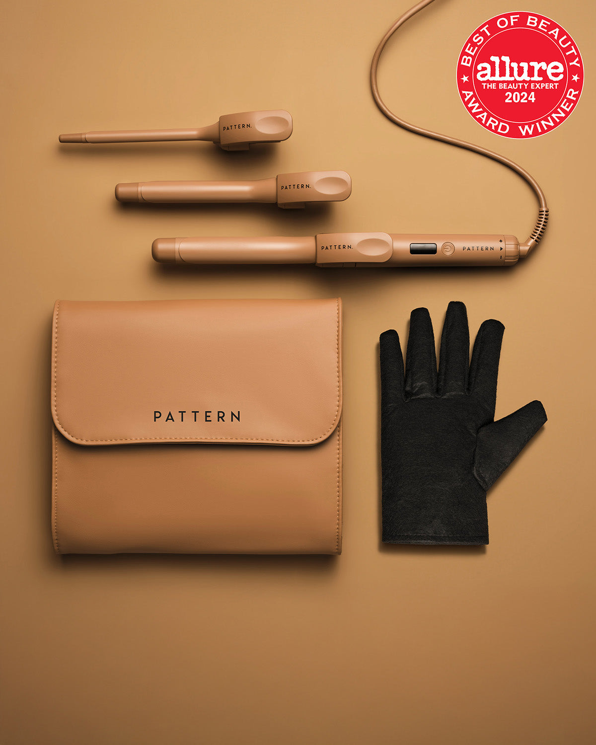 The Interchangeable Curling Iron - Matte gold interchangeable curling iron with two barrel attachments, black heat-resistant glove, and tan PATTERN Beauty zip.