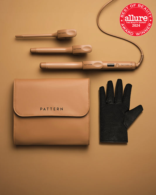 The Interchangeable Curling Iron - Matte gold interchangeable curling iron with two barrel attachments, black heat-resistant glove, and tan PATTERN Beauty zip.