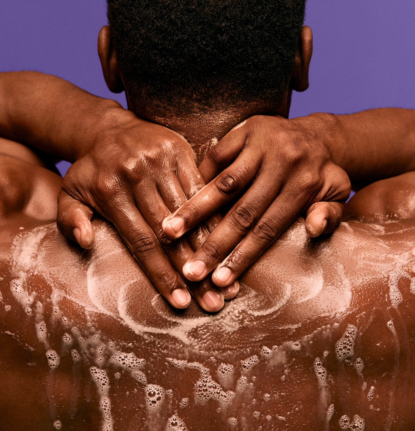 Juicy Hydration Duo - Back view of person with wet skin and lathered soap suds on shoulders highlighting PATTERN Beauty by Tracee Ellis Ross Juicy .