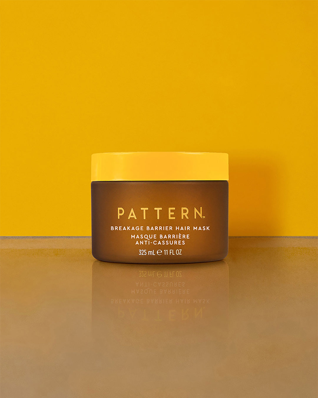 Breakage Barrier Hair Mask - Brown and yellow jar of PATTERN Beauty Breakage Barrier Hair Mask with bold white text on front.