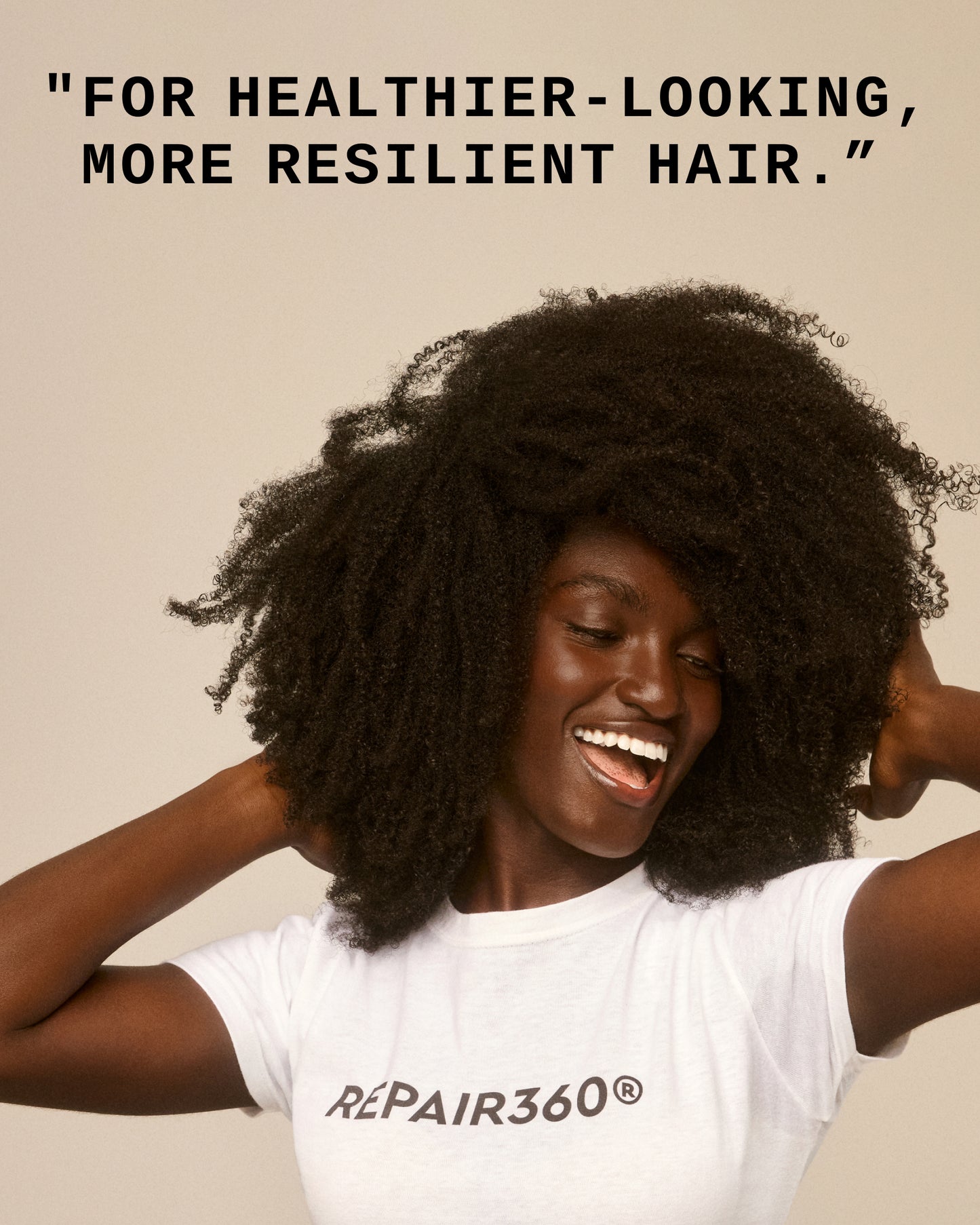 Repair360®  Leave-in Foam - Smiling woman with voluminous natural hair wearing a white Repair360® PATTERN Beauty t-shirt.