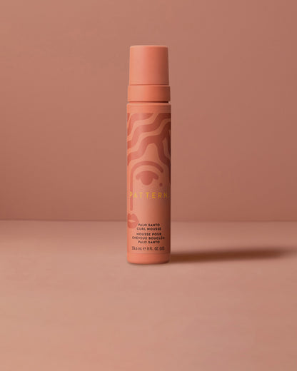 Palo Santo Curl Mousse - Matte peach cylindrical bottle with subtle swirl patterns, labeled PATTERN Beauty Palo Santo Curl Mousse.