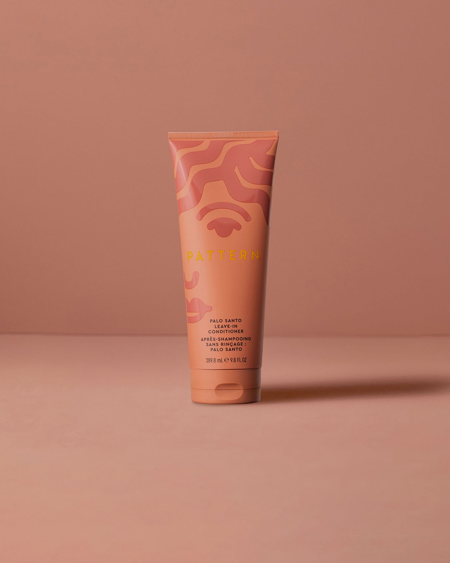 Palo Santo Leave-In Conditioner - PATTERN Beauty by Tracee Ellis Ross Palo Santo Leave-In Conditioner in coral and orange tube with abstract wave design.