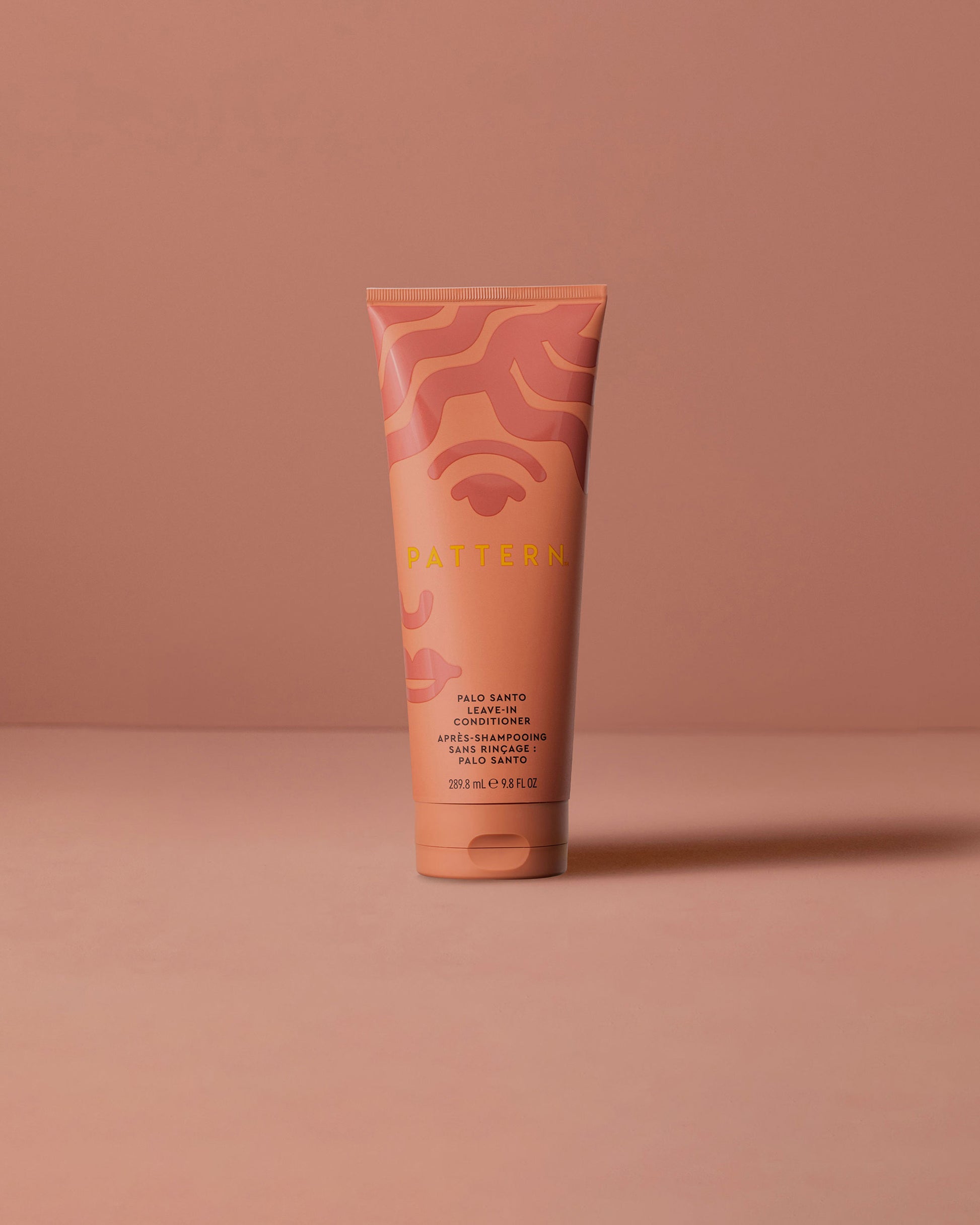 Palo Santo Leave-In Conditioner - PATTERN Beauty by Tracee Ellis Ross Palo Santo Leave-In Conditioner in coral and orange tube with abstract wave design.