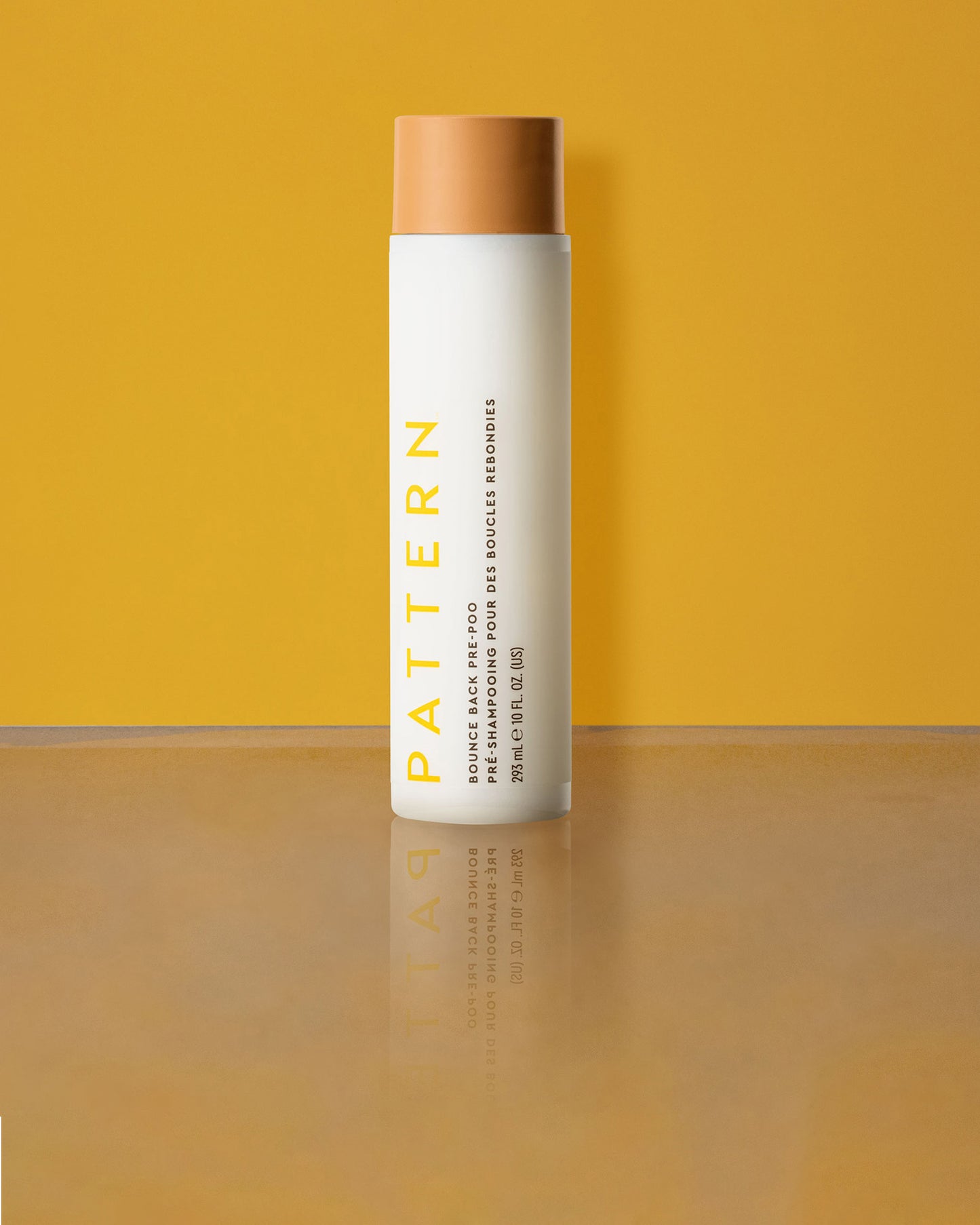 Bounce Back Pre-Poo - White cylindrical bottle with tan cap, labeled PATTERN Bounce Back Pre-Poo by Tracee Ellis Ross against a yellow background.