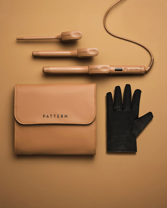 The Interchangeable Curling Iron - Matte gold interchangeable curling iron with two barrel attachments, black heat-resistant glove, and tan PATTERN Beauty zip.