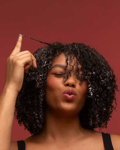 Palo Santo Curl Gel - PATTERN Beauty by Tracee Ellis Ross Palo Santo Curl Gel on coily natural hair with defined, shiny curls against brown.