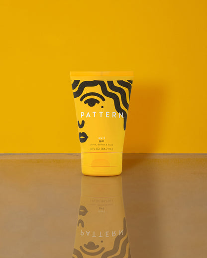 Curl Gel - Yellow squeeze tube of PATTERN Beauty Curl Gel with black abstract face design on front against yellow background.